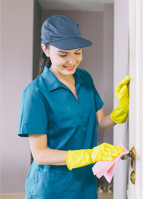 Schoonmaakmedewerker van NOVUS Cleaning reinigt een deurpost